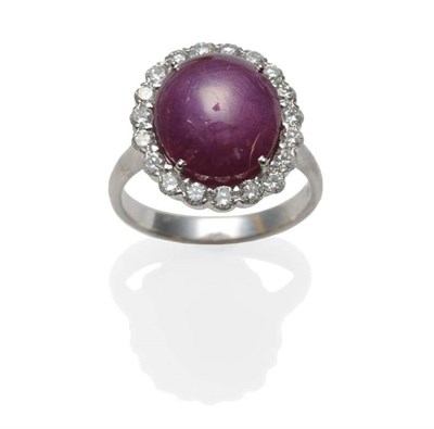 Lot 372 - An 18 Carat White Gold Ruby and Diamond Cluster Ring, the cabochon ruby within a border of...