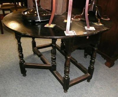 Lot 517 - A stained oak drop leaf table