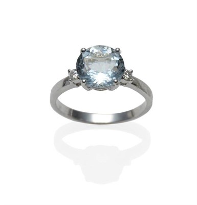 Lot 384 - An Aquamarine and Diamond Three Stone Ring, the round brilliant cut aquamarine between two...