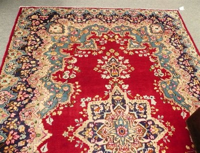 Lot 545 - Kirman carpet South East Persia - The blood red field with central oval medallion, 303 x 198 cm