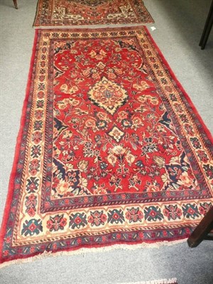 Lot 577 - Hamadan rug West Persia - The tomato red field with central ivory medallion surrounded by...