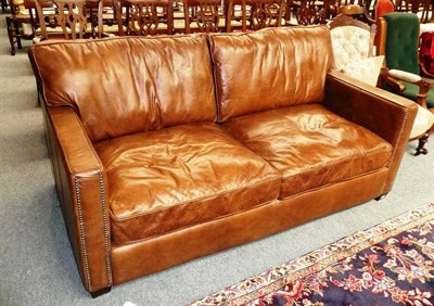 Lot 583 - Modern brown leather three seater settee with studded detailing