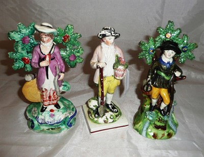 Lot 65 - A 19th century Pearlware figure of a gardener and a pair of bocage figures (3)