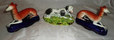 Lot 67 - A 19th century Pearlware figure of a recumbent dog and a pair of Staffordshire pottery...