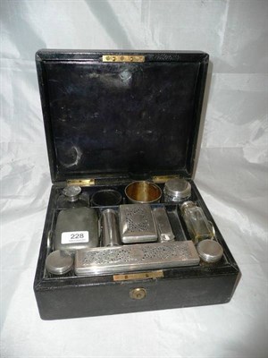 Lot 228 - A leather cased travelling set with cut glass bottles and silver mounts