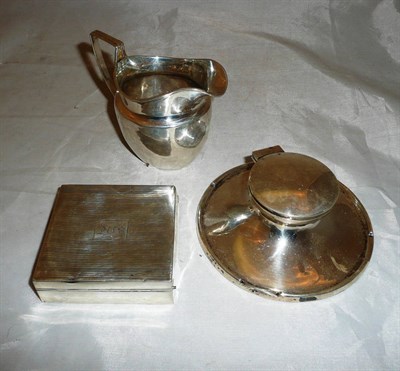 Lot 469 - A silver cigarette box, a Georgian silver cream jug and a silver capstan inkstand