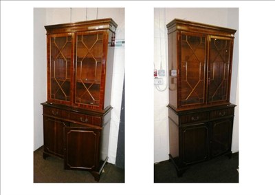 Lot 555 - A pair of glazed reproduction mahogany bookcases with cabinets below