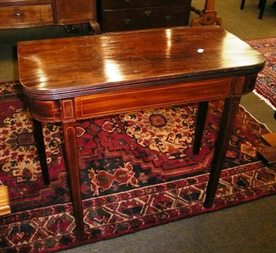 Lot 615 - A Georgian inlaid mahogany fold-over tea table with frieze drawer