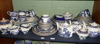 Lot 116 - A shelf of predominantly Willow Pattern dinner and tea services, various makers including Royal...