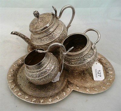 Lot 127 - An Indian silver coloured metal three piece tea set and tray