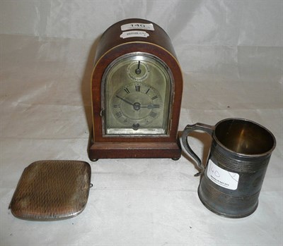 Lot 140 - A silver mug, a cigarette case stamped '0.800' and a mantel clock