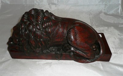 Lot 307 - A hardwood figure of a recumbent lion