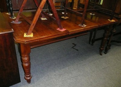 Lot 477 - An Edwardian mahogany wind out dining table with one leaf and winder