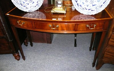 Lot 514 - A reproduction mahogany and satinwood banded bow front serving table with three drawers