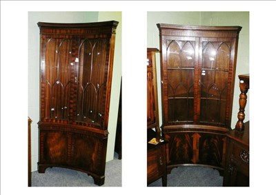 Lot 565 - A pair of inverted bow front mahogany corner display cabinets