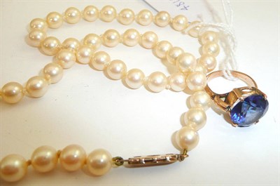 Lot 228 - A simulated pearl necklace with a 9ct gold snap and a synthetic sapphire ring (2)