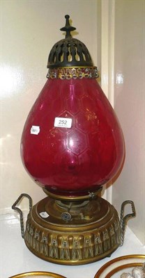 Lot 252 - A large brass and cranberry oil lamp