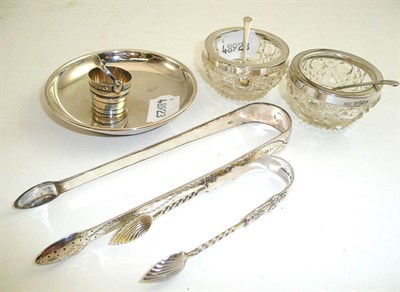 Lot 317 - A small silver ashtray, two pairs of tongs and two salts