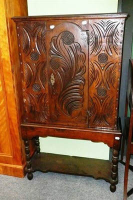 Lot 470 - A carved oak small cupboard on stand