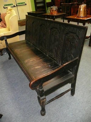 Lot 551 - An oak settle with later carved decoration