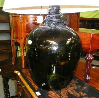 Lot 560 - A large green glass carboy adapted as a table lamp