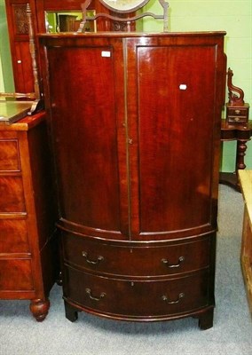 Lot 594 - A small mahogany bow front linen press with two drawers