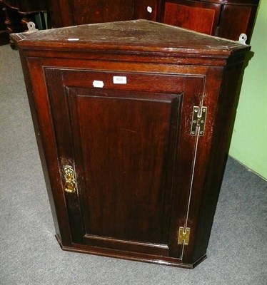 Lot 601 - A George III oak straight front hanging corner cupboard, with H brass hinges