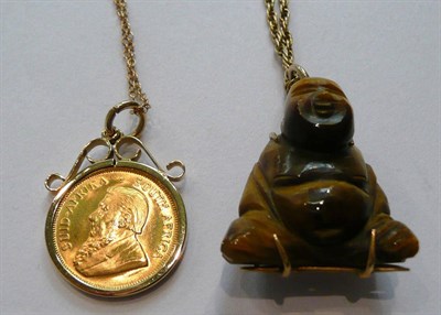 Lot 70 - A 1/10th krugerrand coin loose mounted as a pendant on chain, and a tiger's eye Buddha pendant...