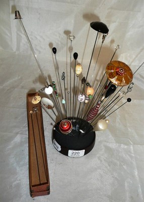 Lot 220 - A collection of hat pins in a stand and a hat pin box