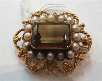 Lot 324 - A Smokey Quartz Brooch, the oblong step cut smokey quartz within a border of half pearls, to an...