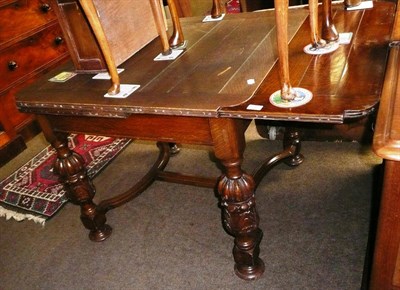 Lot 532 - An oak draw leaf table with heavily carved legs