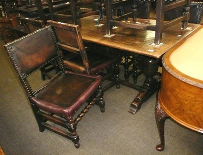 Lot 556 - Oak refectory style table and eight leather covered dining chairs, with brown velvet cushions,...