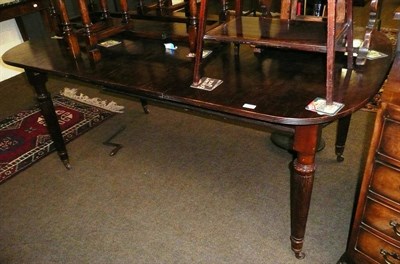 Lot 560 - Mahogany extending dining table on reeded legs