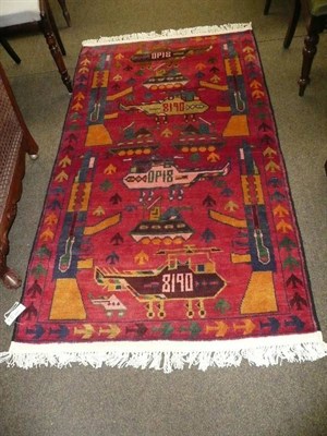 Lot 597 - Afghan war rug North West Frontier Province, The blood red field with weapons of war enclosed...