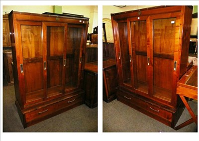 Lot 624 - Two modern mahogany and oak glazed bookcases with drawers below, leather handles and studded...