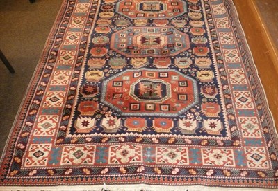 Lot 677 - A large red ground patterned Eastern carpet