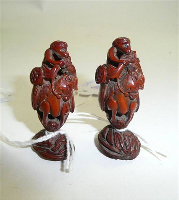 Lot 161 - A pair of Chinese carved peach stones depicting monkeys on horseback