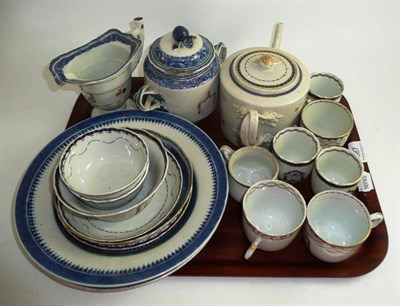 Lot 387 - A collection of Chinese export armorial porcelain including tea pot, cups, saucers, sucrier and jug