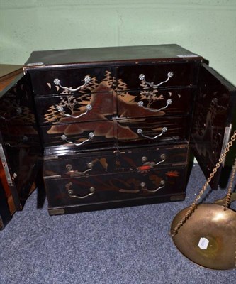 Lot 421 - A Japanese lacquered cabinet with brass fittings