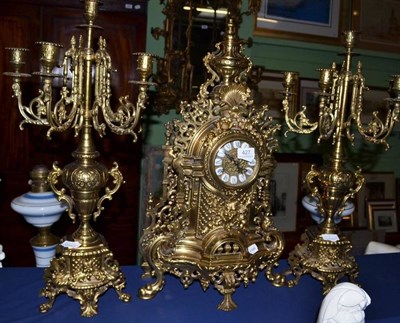 Lot 427 - A decorative brass mantel clock with a pair of matching candelabrum