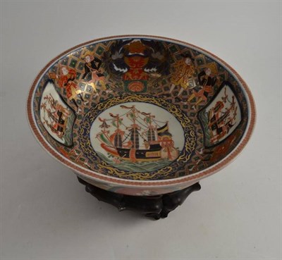 Lot 431 - A Chinese porcelain bowl decorated in Imari colours with ships and figures with wood stand