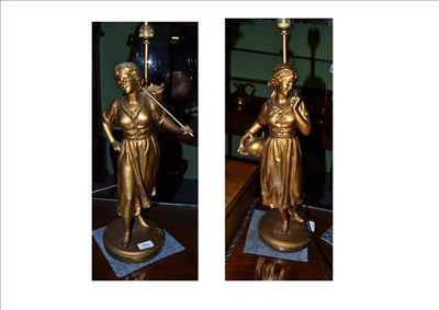 Lot 442 - A pair of French spelter female figural lamps, later painted in gold