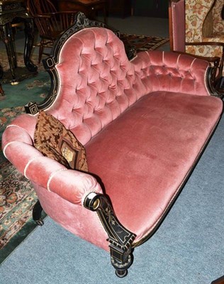 Lot 628 - A Victorian ebonised settee with button back upholstery