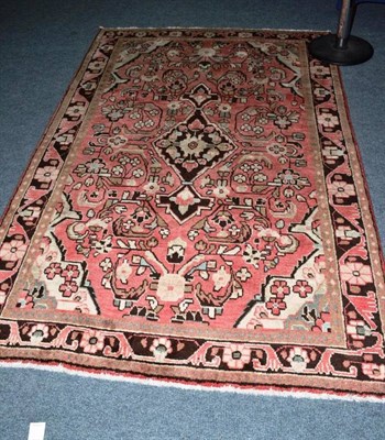 Lot 640 - Arak rug West Persia, the faded rose pink field centred by a medallion enclosed by vine...