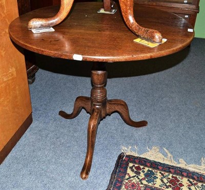 Lot 678 - An oak tripod table on turned column