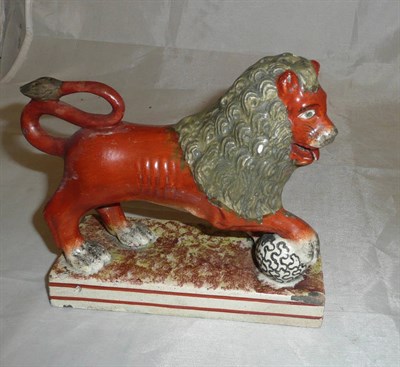Lot 10 - A 19th century English pottery sponged lion and ball figure