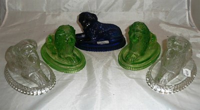 Lot 31 - A pair of green tinted pressed glass recumbent lions marked J.D & Anchor; a clear glass pair of...