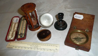 Lot 39 - A 19th century pocket compass in a mahogany case; a treen hour glass; a cased thermometer by...