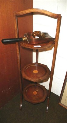 Lot 257 - An Edwardian inlaid mahogany folding cake stand, a copper and steel sovereign shovel and a...