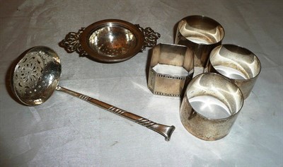 Lot 318 - A silver sifter spoon, silver strainer and four napkin rings